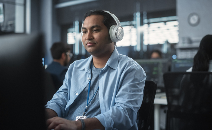 Software developer wearing headphones while working on computer