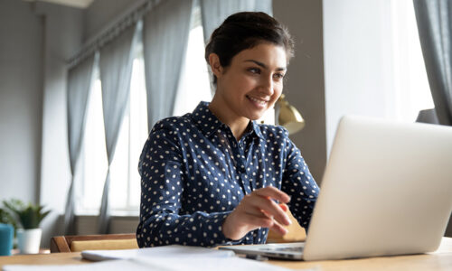 Smiling woman working on a laptop