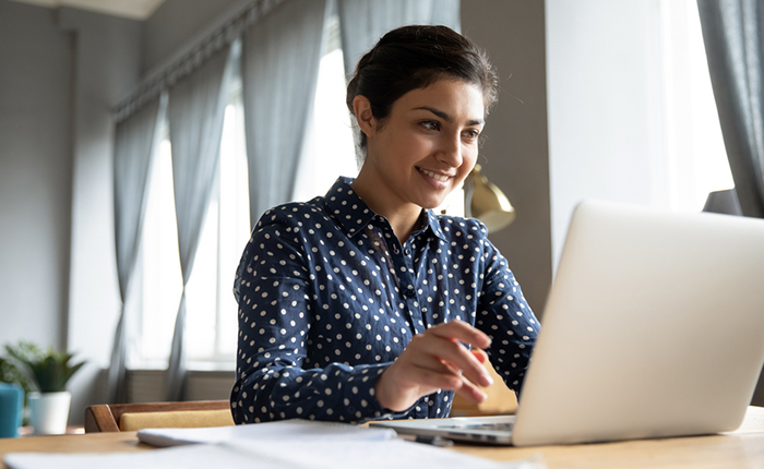 Smiling woman working on a laptop