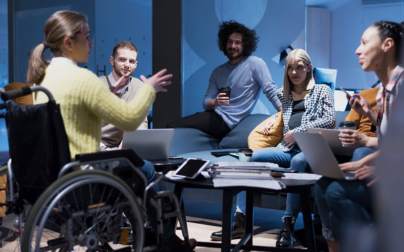 Students in a group discussion lead by a woman with a disability in a manual wheelchair