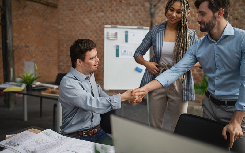 Man being introduced and shaking the hands of a colleague as part of job placement assistance