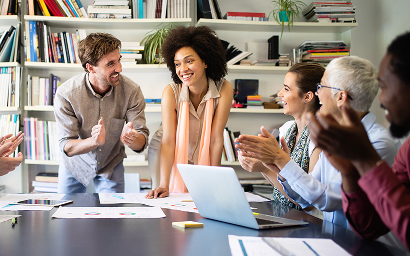 Woman being congratulated by colleagues at job placement