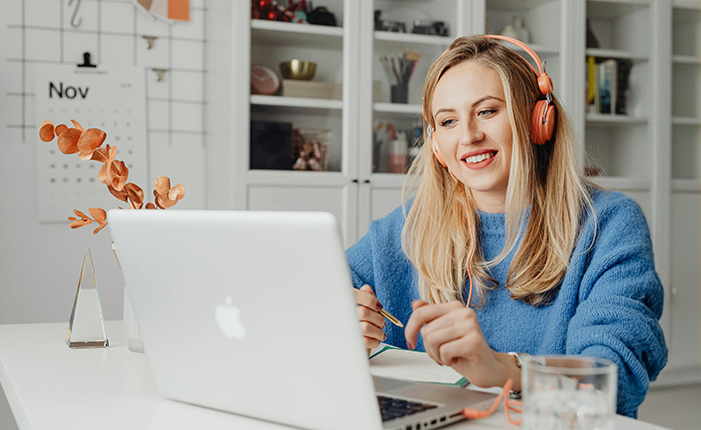Femme avec un casque travaillant sur un ordinateur portable